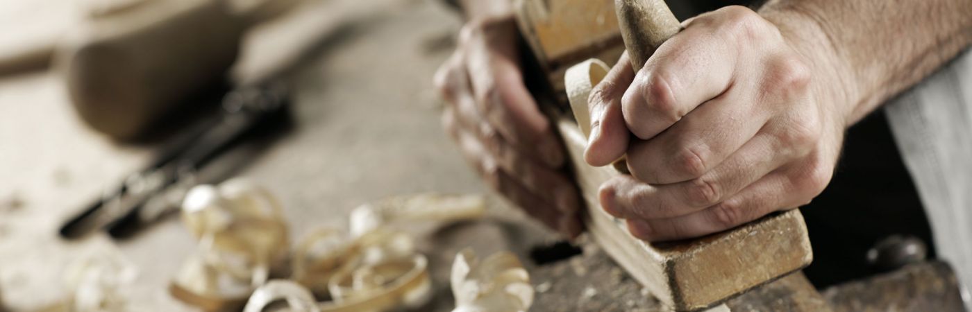 stock-photo-hands-of-a-carpenter-planed-wood-workplace-110356841